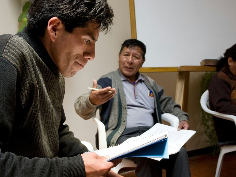 Adults reading and consulting together in a Bahá’í study circle
